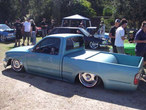 Turquoise slammed minitruck with tailgate open showing custom modifications at Half Way Havoc